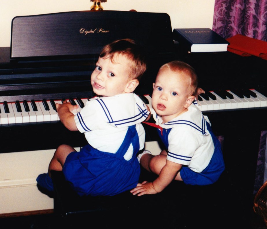 two young boys sitting at the piano